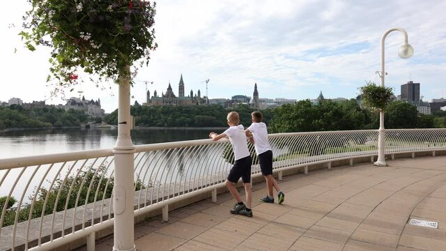 Boys look across the river from the Gatineau side at the Parliament of Canada