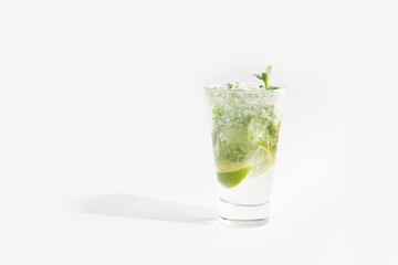 cocktail in a glass with ice, lime and greens. Mojito.