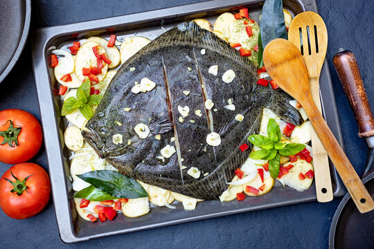 Mariscos y pescado frescos. Pescado entero de rodaballo para cocerlo en horno con patatas, pimiento y hierbas arom&aacute;ticas.