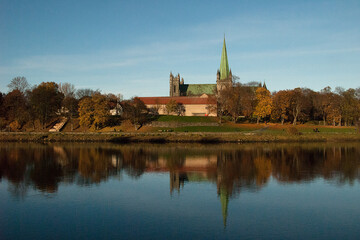 Fototapeta na wymiar View of Nidarosdomen, Trondheim, Norway, beautiful reflected in calmly floating river Nidelven.