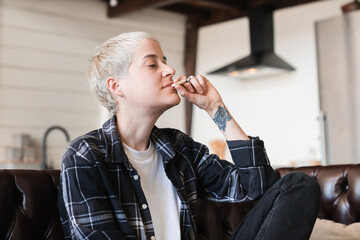 Hipster woman girl smoking cigarette joint with marijuana cannabis tobacco hashish. Legalization of...