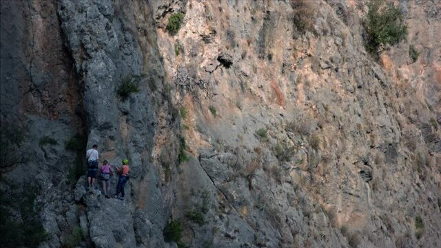 Rocky cliff of the mountain. People climbing on the rock.