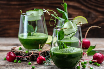 Glass with green homemade smoothies, Detox smoothie, green fresh peas, cucumber, radish, spinach and lime