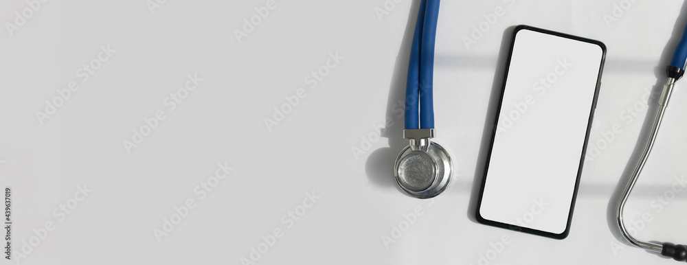 Leinwandbilder Mobile phone mock up with sthethoscope over white background. Template with white screen of smartphone with copy space.
