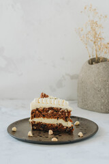 Piece of carrot homemade cake with white cream on a white background.