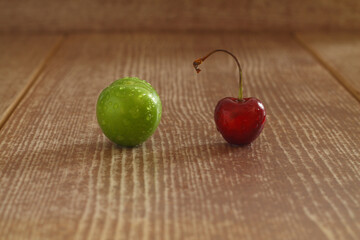 Single whole fresh green Can Erik plum and cherry close up isolated on dark background. green plums and cherry pictures from the first fruits in summer