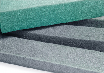 transverse pile of green and gray spongy foam material in blocks or bars