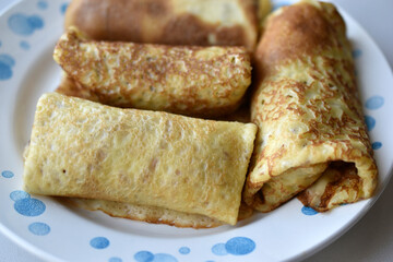 Delicious pancakes with meat on a plate on a white background