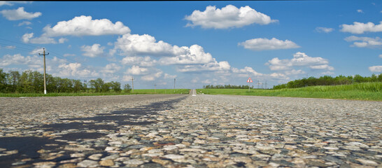 the road leading into the distance clouds and fields