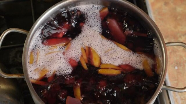 Cooking compot. beverage made of variety of fresh berries. Boiling water with berries in saucepan. Slow motion. refreshing drink with bubbles, foam. homemade compote. Top view. Full hd