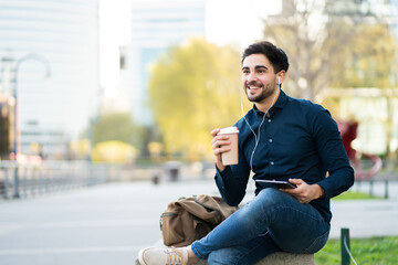 Fototapeta premium Young man using digital tablet outdoors.