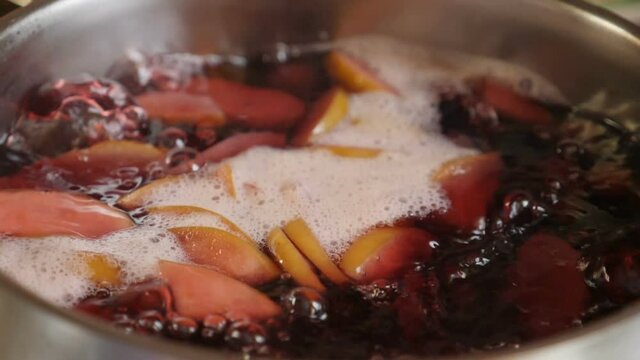 Cooking compot. beverage made of variety of fresh berries. Boiling water with berries in saucepan. Slow motion. refreshing drink with bubbles, foam. homemade compote. Top view. Full hd