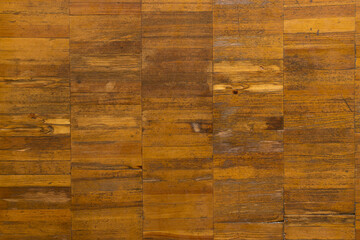 Old light brown wooden parquet, close-up background with cracks and scratches, pattern and texture