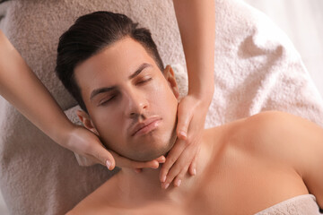 Fototapeta na wymiar Man receiving facial massage in beauty salon, top view