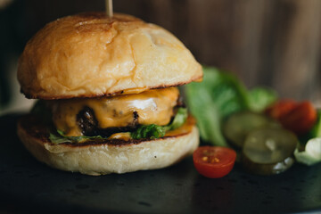 Fresh tasty burger on old dark wooden table