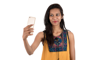 Fototapeta premium Portrait of a happy young girl using mobile phone isolated over white background