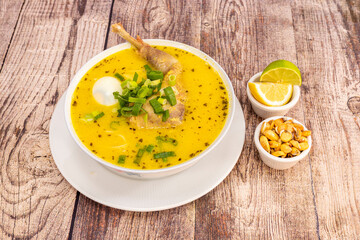 Old chicken broth with typical Peruvian recipe accompanied by a bit of cancha and slices of lime...