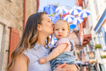 Fototapeta premium Young mother on street with tiny daughter girl