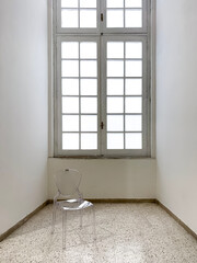 The many degrees of transparency of a white window and a plastic chair