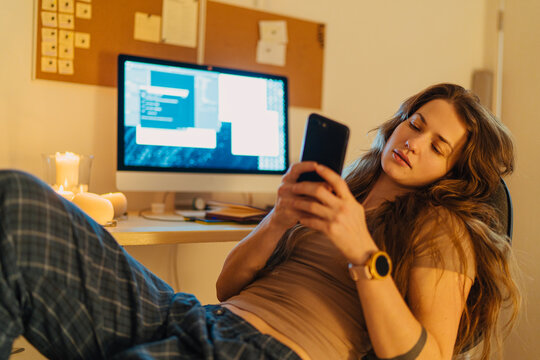 young woman checking her smartphone while perusing at work