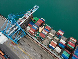 crane loading shipping containers to cargo boat ship in the port