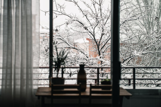 Table in room on background of snowy trees behind window