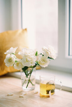 white roses in a vase and green tea