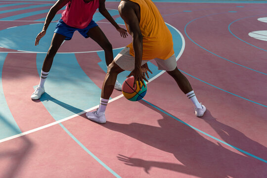 Two young African American men playing basketball.