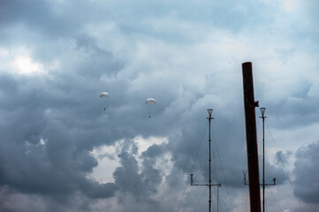 two parachutists descend by parachute / paratroopers /