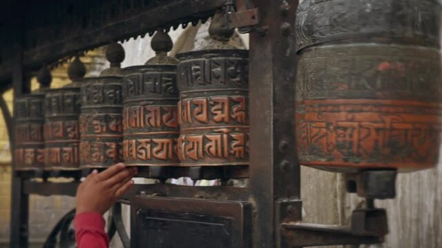 hands on buddhist prayer wheels in temple