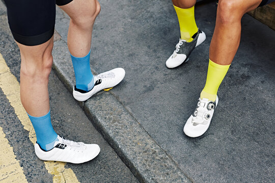Cycling female cyclist hanging with friends on bike ride sitting on pavement cobbles Chill Relax London