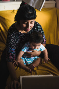 Mom working from home while holding child