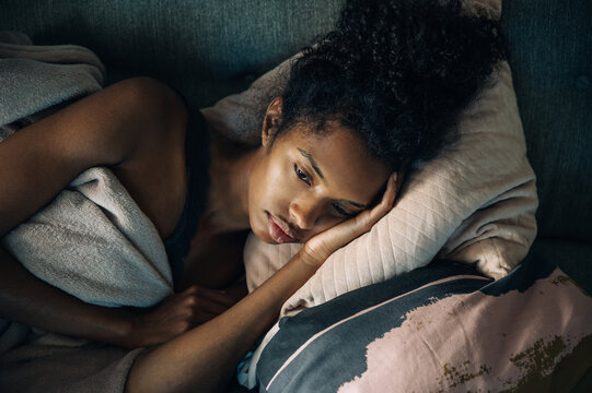 Depressed black woman lying on sofa
