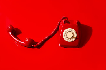 red rotary dial telephone off the hook
