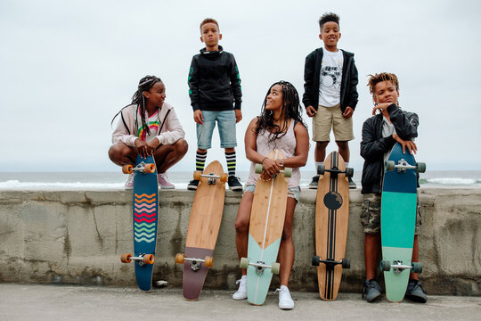 Black family with skateboards on seawall