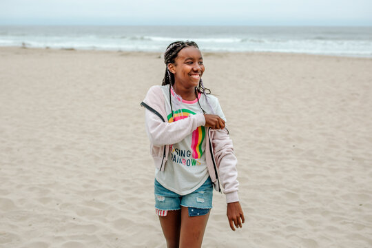 Happy African American girl walking at beach