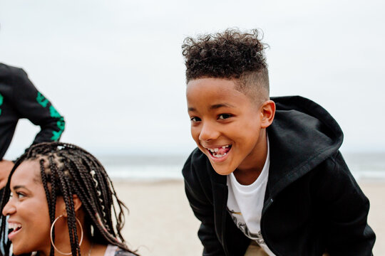 Mischievious boy wearing sweatshirt at beach