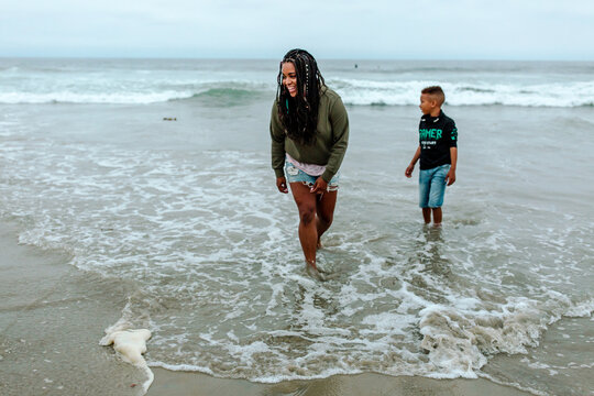 Mother and son wading in ocean