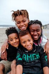 Naklejka premium Laughing African American siblings at beach