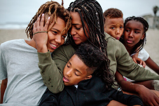 Mother hugging children at beach