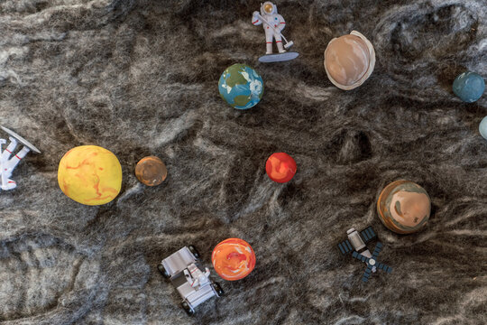 space toys on a wool rug that looks like the moon 1