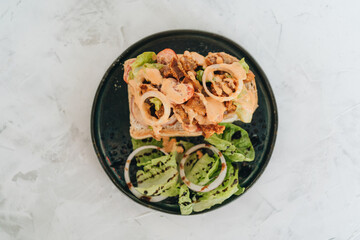 Toast with crispy fried spicy chicken, onion and sause