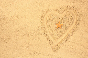 Silhouette of a heart on the background of a sandy beach, a starfish in the center. The concept of tourism, vacation, travel. Mock up for design with copy space, top view.
