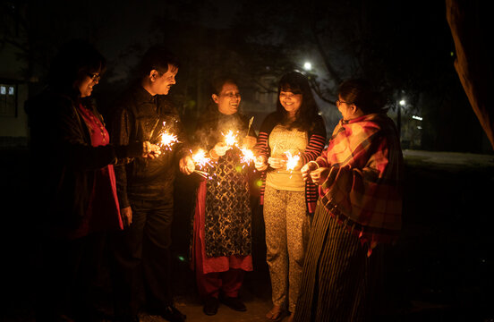 Indian family burning sparklers and celebrating Diwali at outdoors