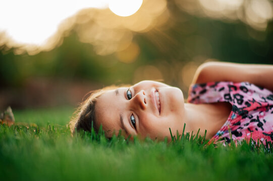 Girl laying in grass smiling. 