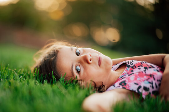 Young child laying in grass relaxing. 
