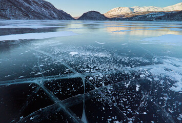Methane CH4 bubbles frozen under water of Arctic lae ice - fractures, patterns and shapes