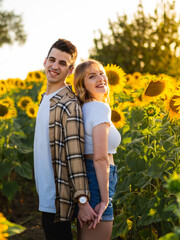 Pareja joven disfrutando de sus vacaciones de verano en un campo de girasoles