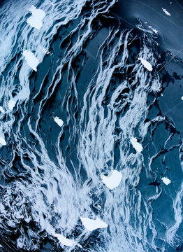 Abstract patterns of snow frozen on Arctic lake surface ice - artistic design by nature