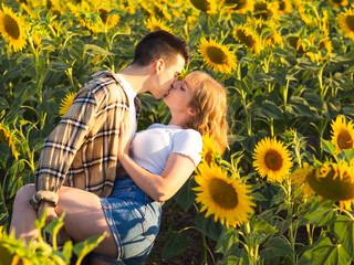 Pareja disfrutando de su amor en las vacaciones de verano en un campo de girasoles 